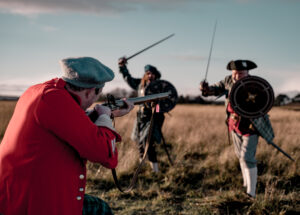 two men with swords charging at a man with a musket at Culloden